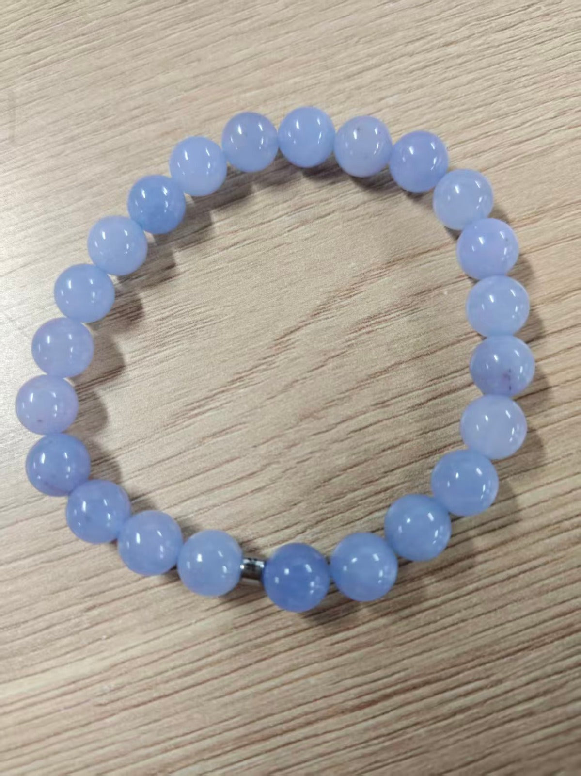 Bracelet en pierre naturelle bleue translucide posé à plat