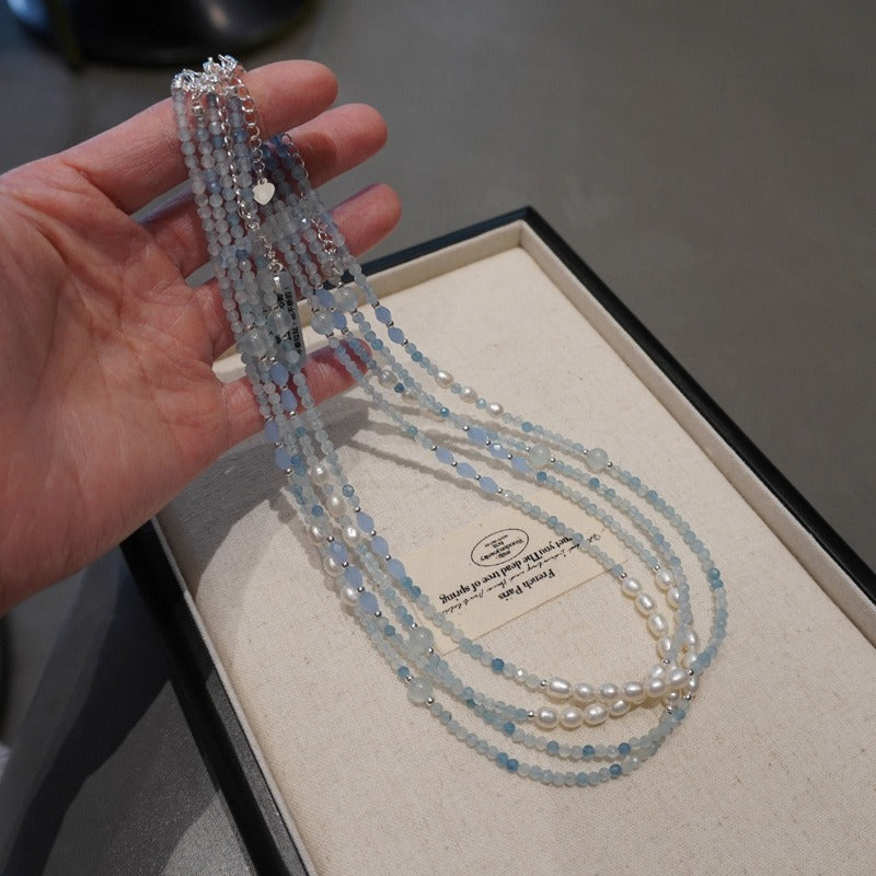 Collier Douceur de la Mer en aigue-marine tenu en main