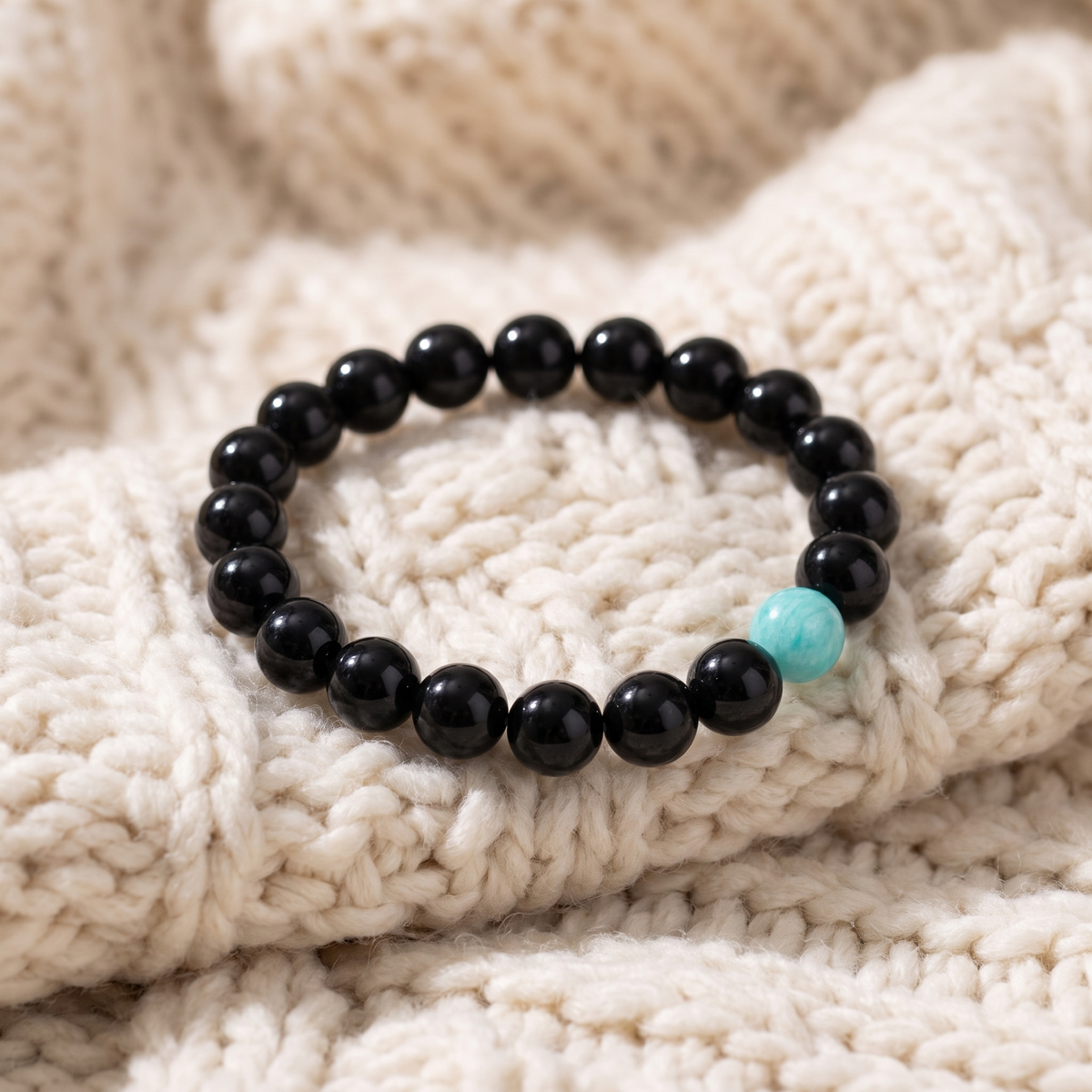 Bracelet Anti-Stress en Onyx Noir et Amazonite sur plaid en maille crème