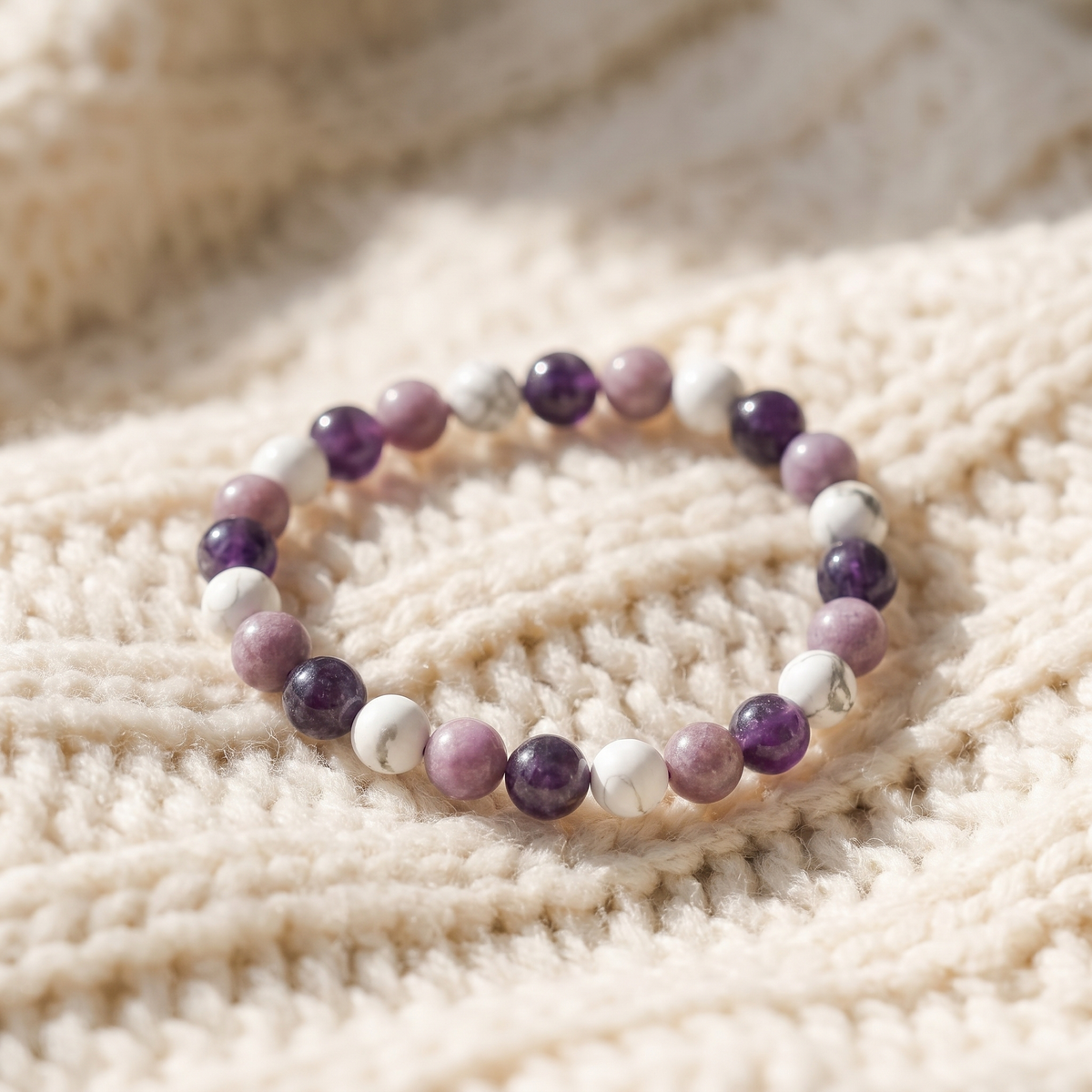 Bracelet Sommeil Apaisé en Améthyste, Howlite et Lépidolite sur plaid en maille crème