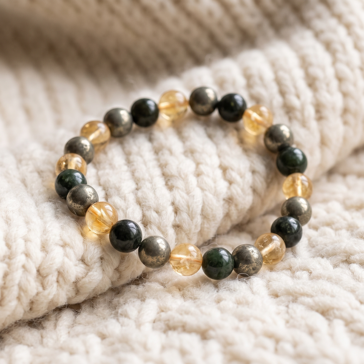 Bracelet Abondance et Prospérité en Citrine, Pyrite et Jade sur plaid en maille crème